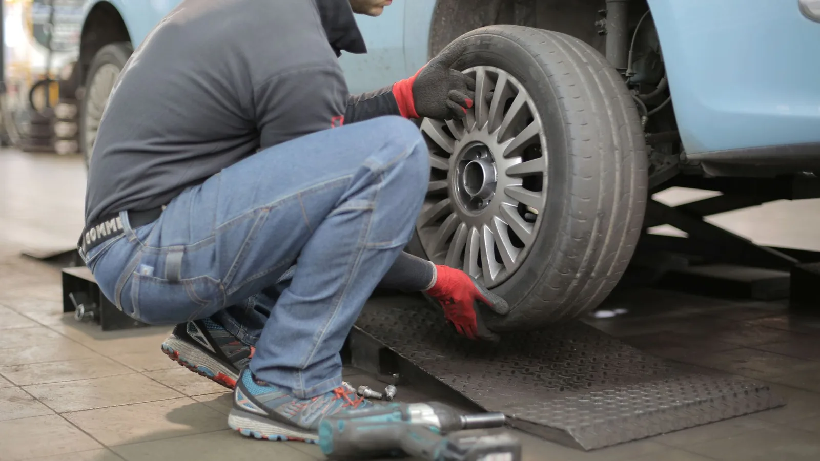 Technician jump-starting a car battery on a Madera street