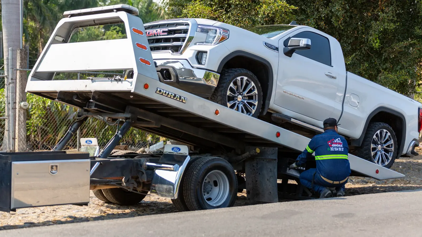 Tow truck loading a car on the shoulder of SR-99 in Madera, CA